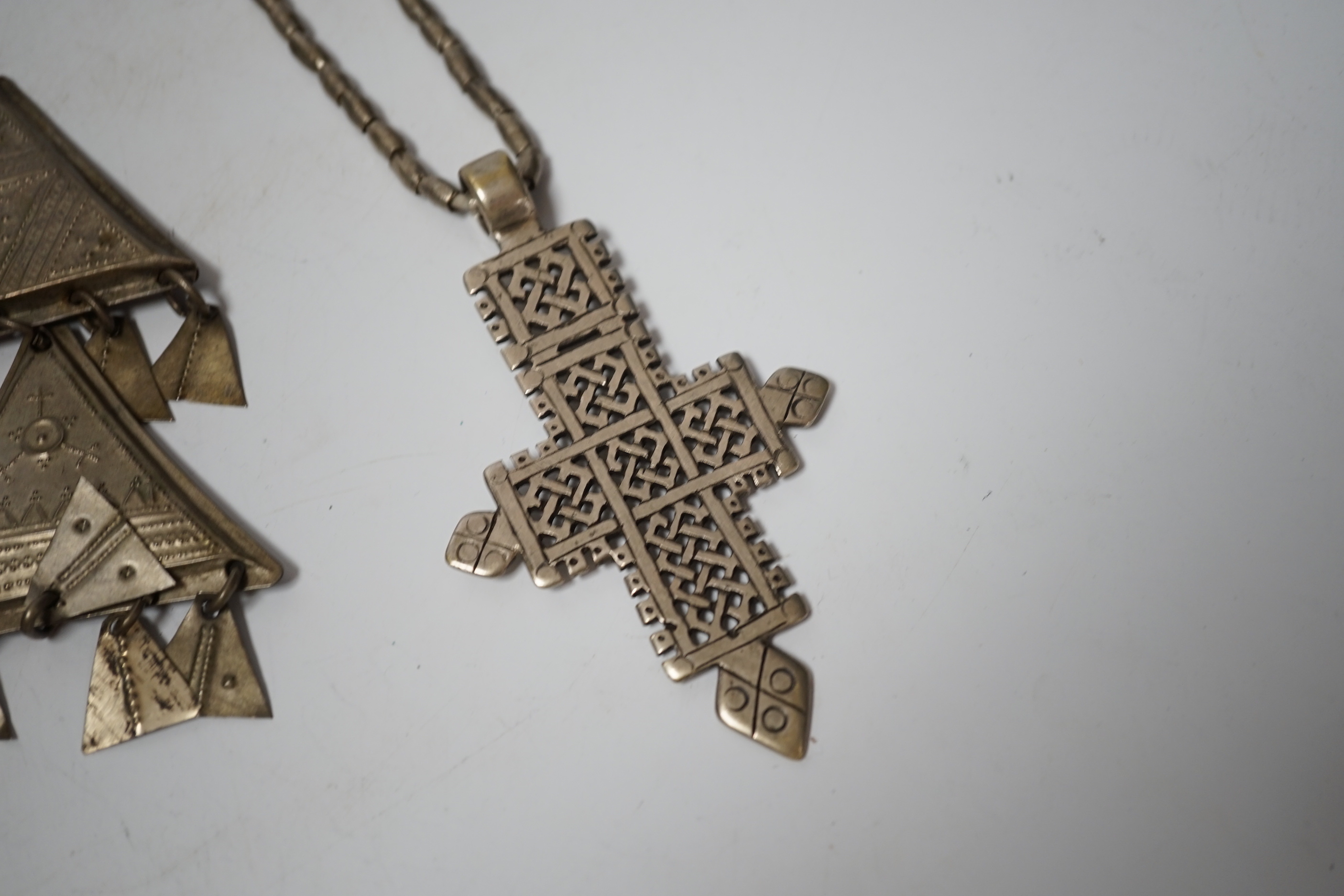 An Ethiopian white metal cross pendant necklace, overall 90cm, together with a pair of Tuareg silvered metal drop earrings (lacking hooks), approx. 12cm.